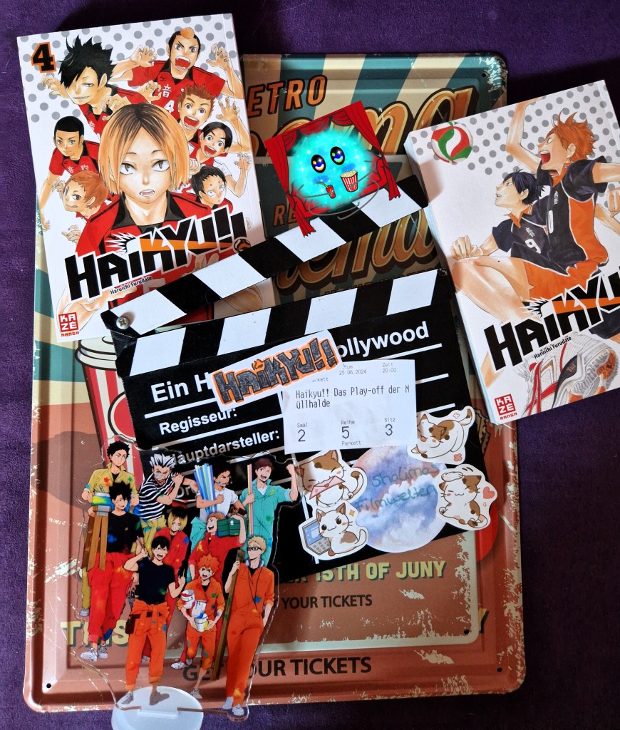 Filmklappe mit Kinokarte und selbstgemaltem Titel zum Film Haikyuu mit zwei Mangabänden und einem Acrylständer zu der Reihe.