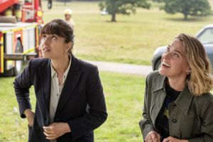 DI Esther Williams und Martha Floyd schauen kritisch bzw. amüsiert zu etwas außerhalb des Bildes