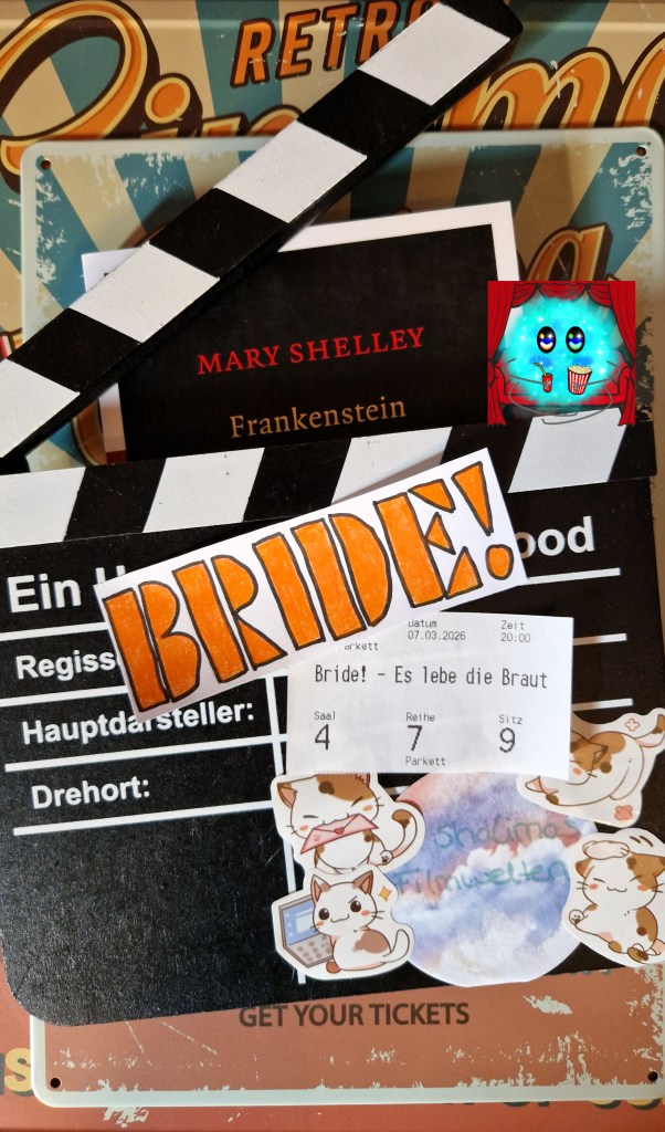 Fanart des Filmtitels auf einer Filmklappe. Dahinter liegt eine Ausgabe von Frankenstein