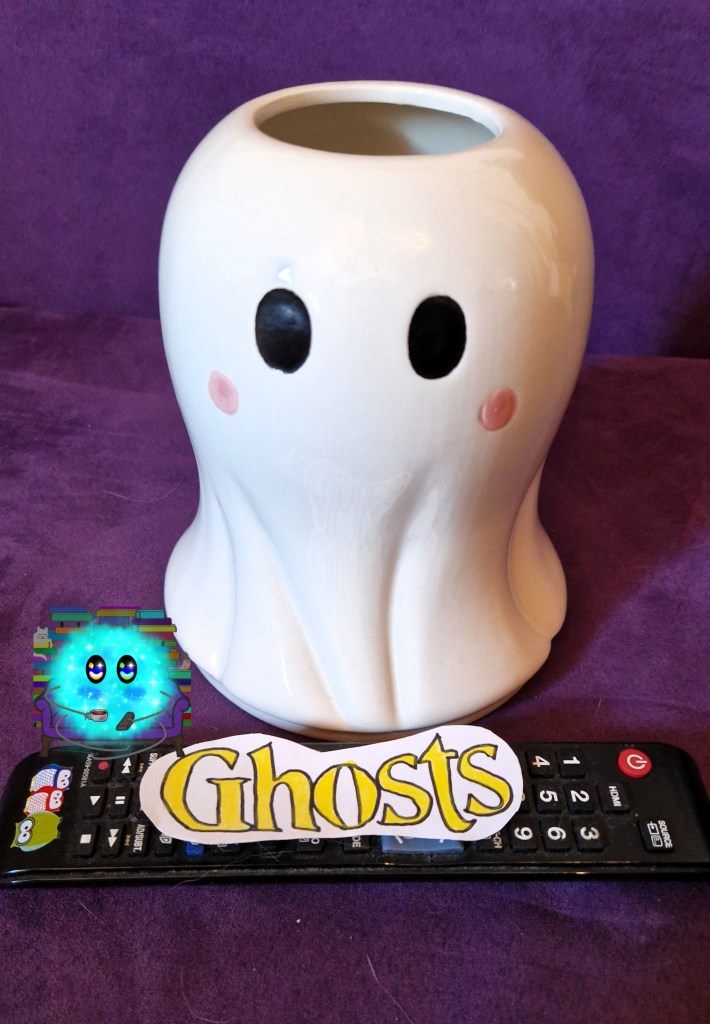 Fanart des Titels auf einer Fernbedienung vor einer Vase in Geisterform